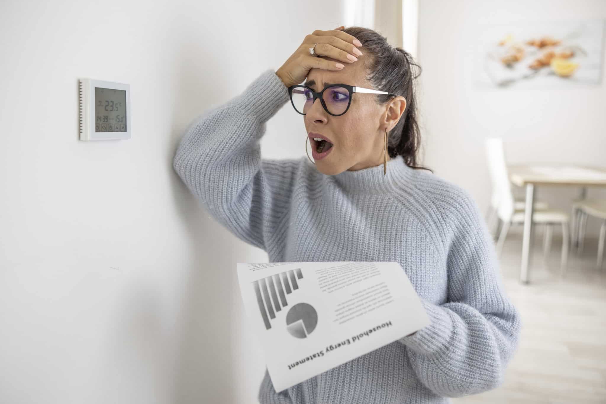 Frustrated woman reviewing monthly heating bill