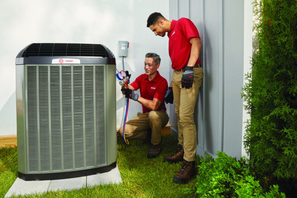 Technicians working on an outdoor air conditioner unit
